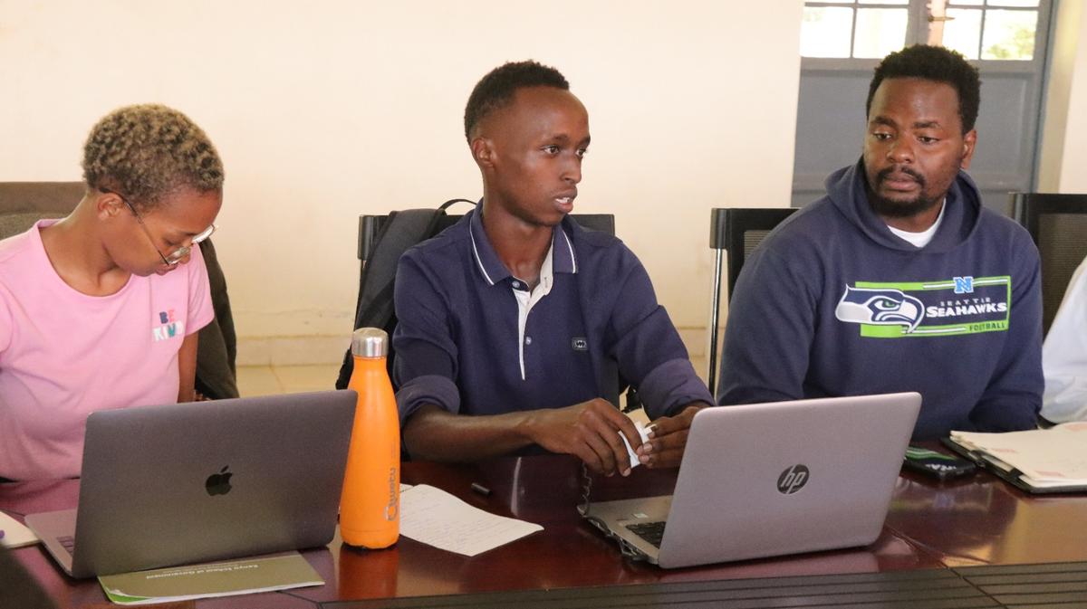 Ganjisha students working together on laptops during a training session in Narok